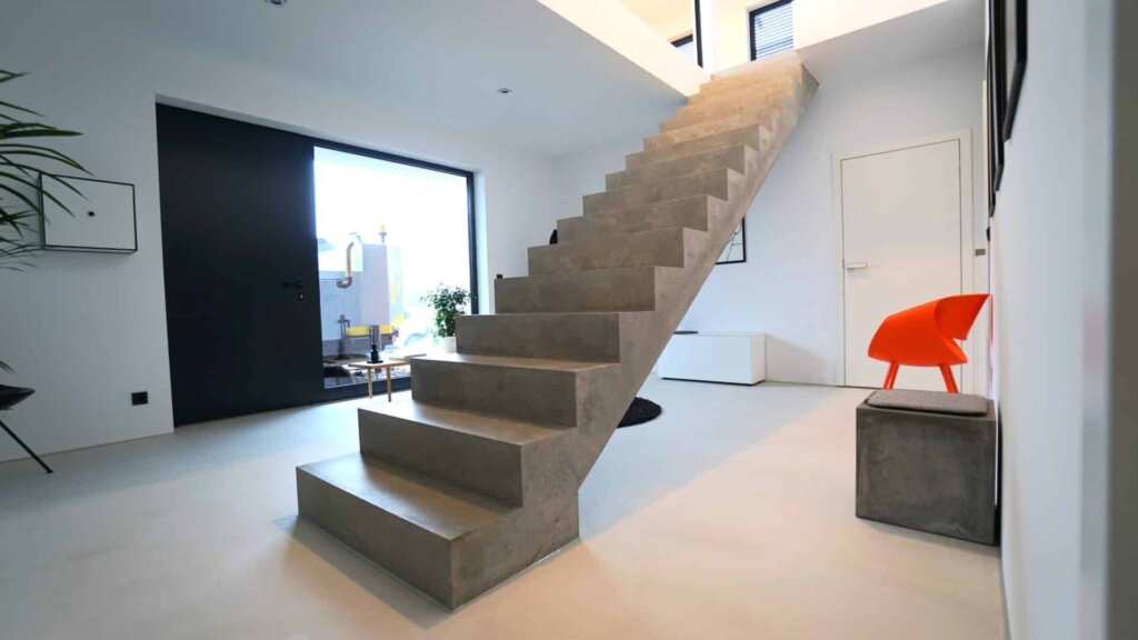 Helle Wandflächen und weiße Tür neben einer offenen Treppe
