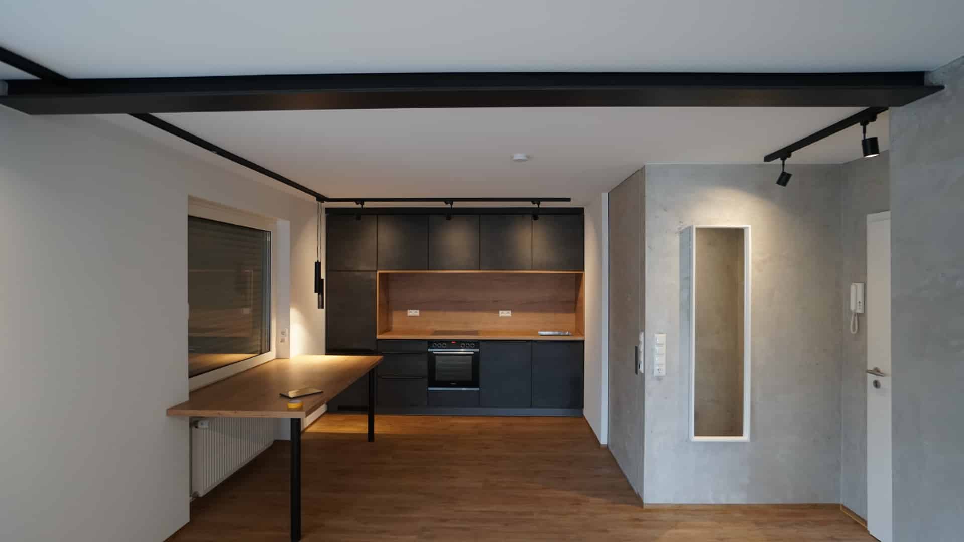 Fertiggestelltes Zimmer in Bielefeld mit edlem Putz, Trockenbau-Decke, tapezierten und gestrichenen Wänden sowie eingebauter Küche