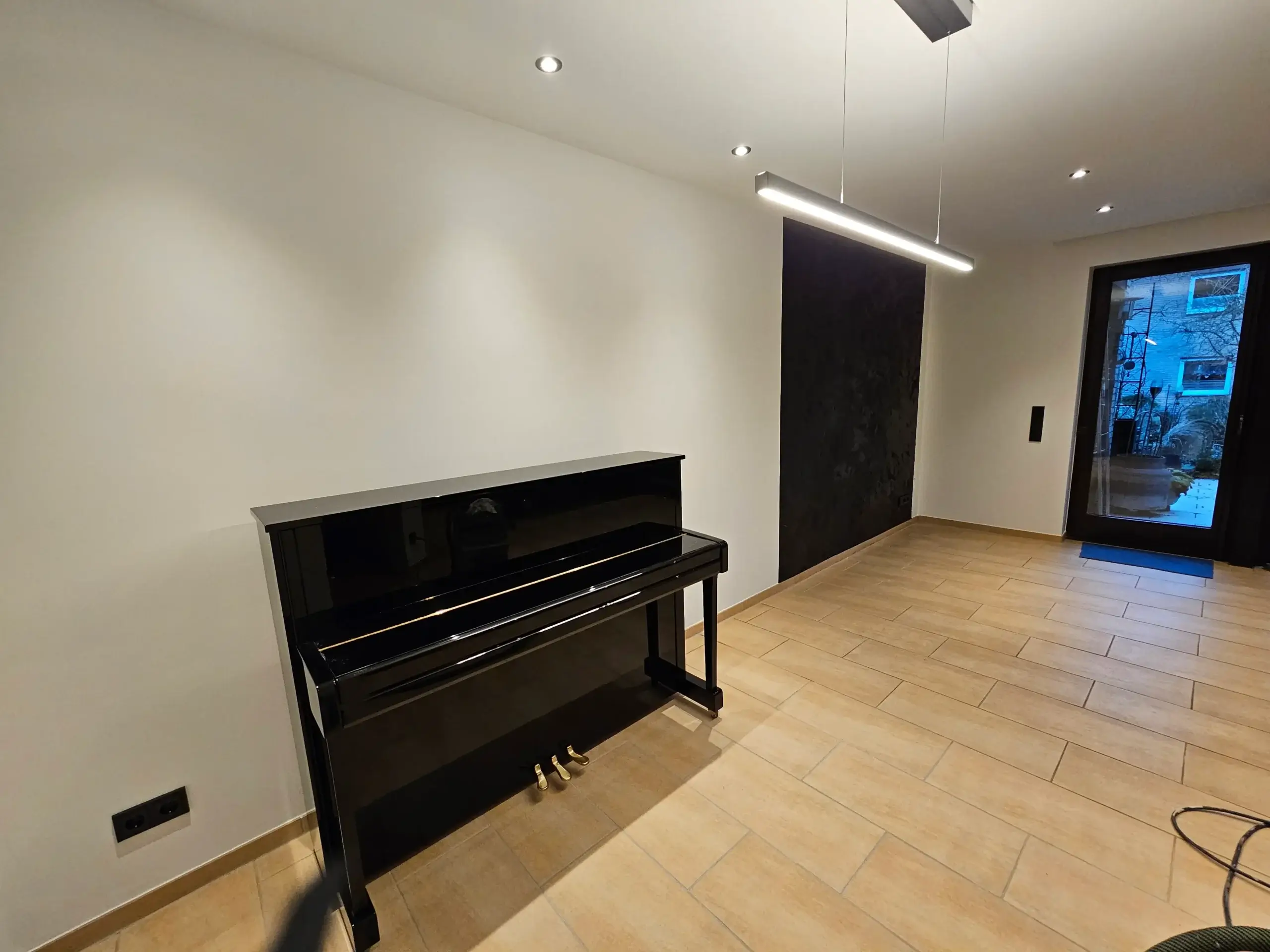 Modern gestrichenes Wohnzimmer mit Akzentwand und Deckenbeleuchtung nach Malerarbeiten in Bielefeld