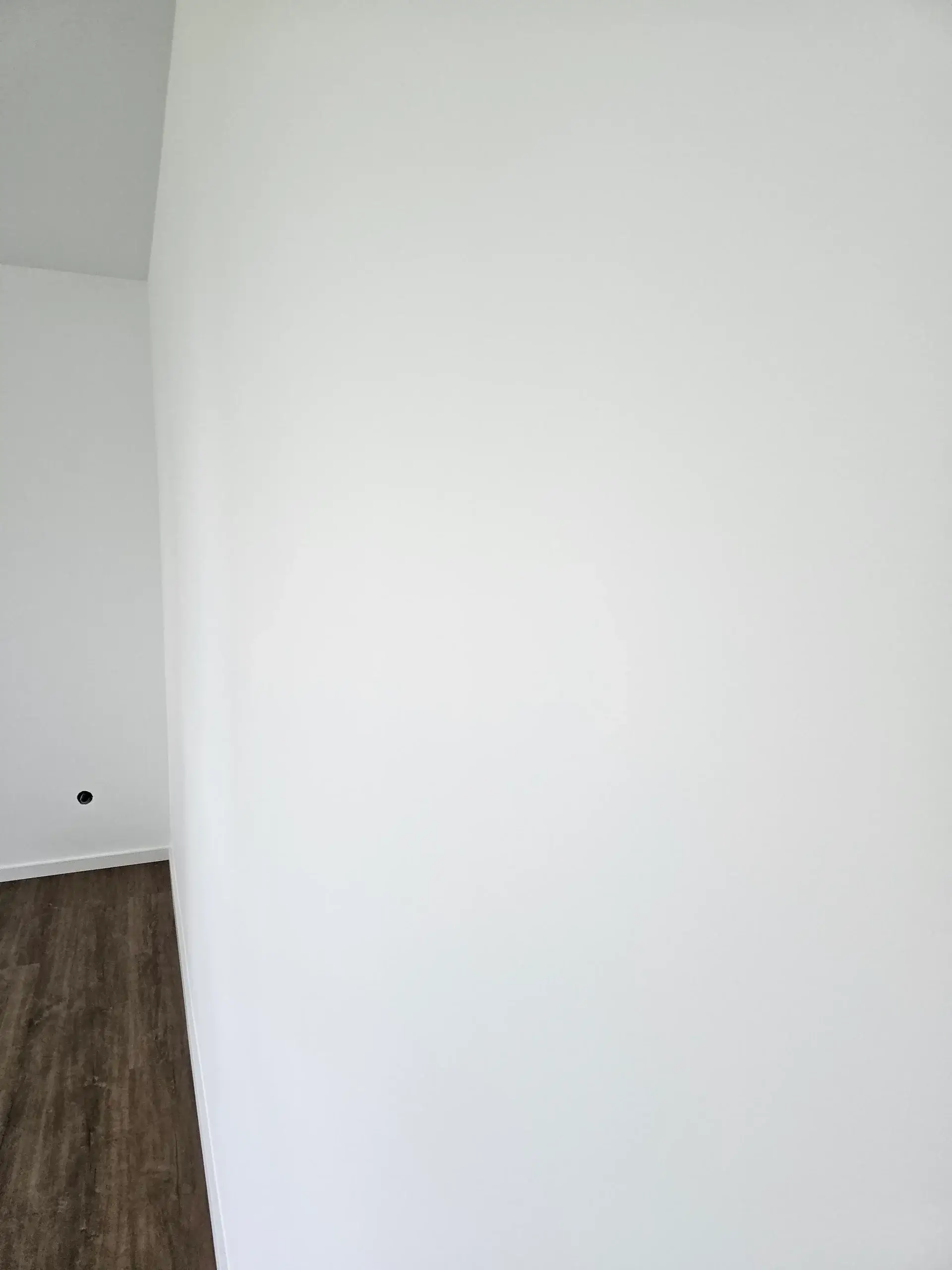 Weiße, glatt gestrichene Wand nach Malerarbeiten mit sauberem Wand-Boden-Anschluss in Bielefeld